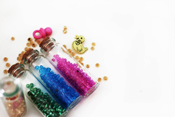 Bouteilles en verre minuscules remplies de perles et d'éléments colorés pour
  - Photo, image