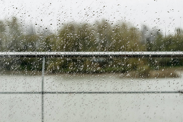 Regentropfen auf das Glas mit Blick auf den Fluss. - Foto, Bild