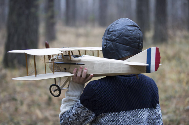 un garçon joue dans les bois avec un avion jouet. Jeux d'automne dans le w
 - Photo, image