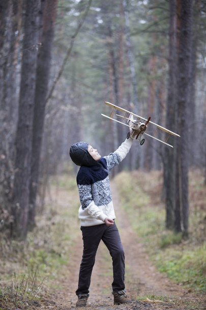 egy kisfiú játszik az erdőben egy játék síkon. őszi játékok a w - Fotó, kép