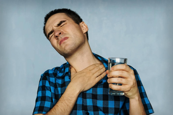 Retrato hombre tosiendo, presionando en el pecho con expresión dolorosa
. - Foto, imagen