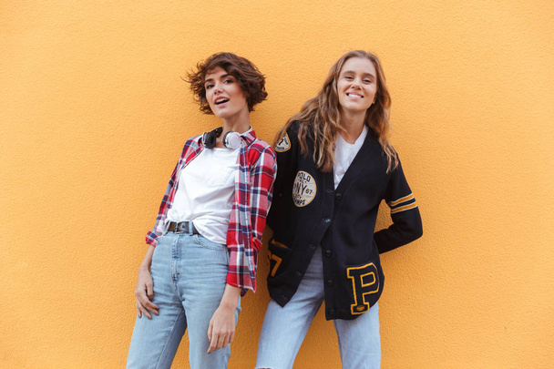 Dvě usměvavé mladé dospívající dívky představují - Fotografie, Obrázek
