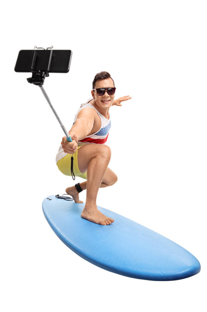 man surfing and taking a selfie with a stick - Foto, immagini