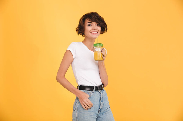 Portrait of a smiling casual girl drinking orange - Фото, зображення