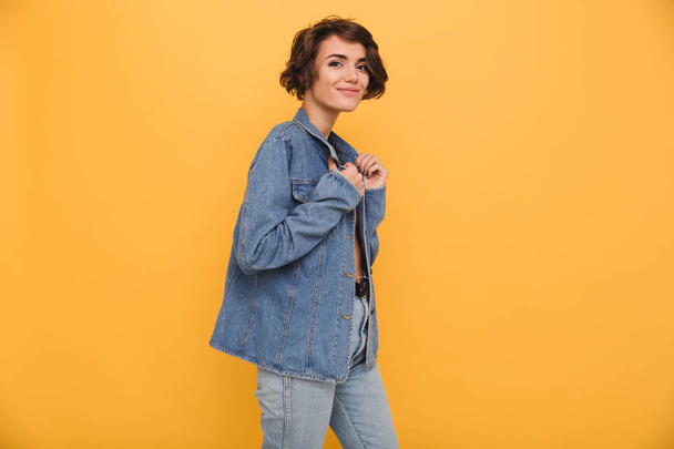 Portrait of a young smiling woman dressed in denim jacket - 写真・画像