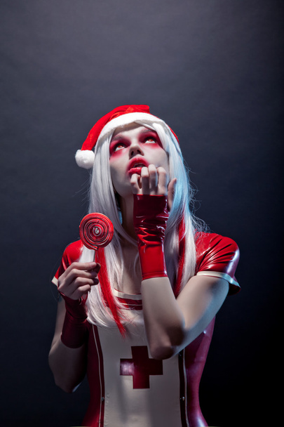 Santa Claus helper woman in red latex outfit - Фото, изображение
