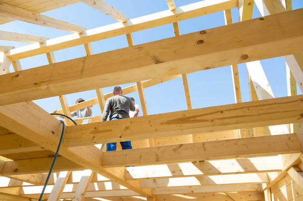 Builders at work with wooden roof construction. - Photo, Image