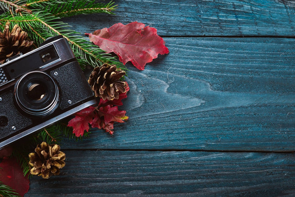 Camera Christmas wooden background. New Year's holiday. Christmas motive. On a wooden surface. Top view. Free space for your text. - Photo, image