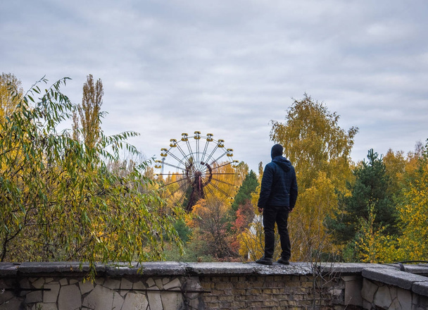 Homens no topo do telhado na cidade abandonada de Pripyat na Zona de Exclusão de Chernobyl no outono
 - Foto, Imagem
