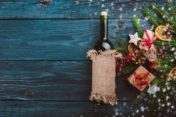 Christmas wooden background. A bottle of wine. New Year's holiday. Christmas motive. On a wooden surface. Top view. Free space for your text. - Photo, image