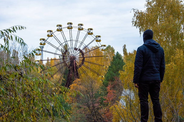 Men on the top of the roof at abandoned Pripyat city in Chernobyl Exclusion Zone at autumn time - Photo, Image