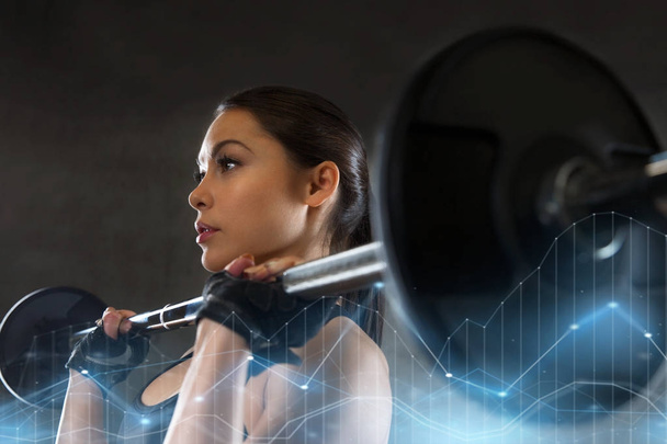 young woman flexing muscles with barbell in gym - Foto, Imagen