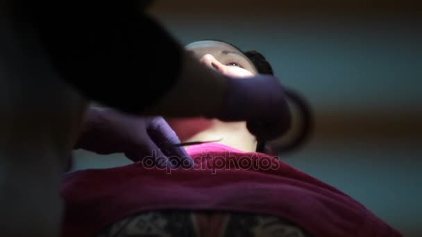 dentysta jest zakładanie szelki zęby młoda kobieta - Materiał filmowy, wideo
