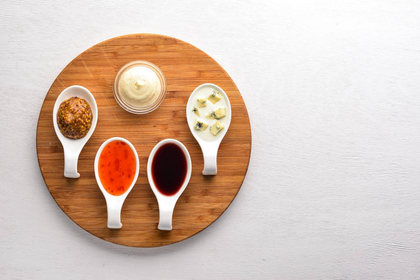 A set of sauces and spices. On a wooden background. Top view. Free space for text. - Фото, зображення