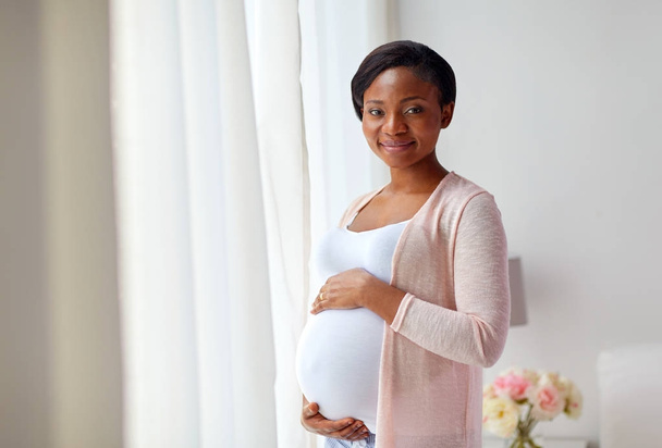 pregnant african american woman at home window - Foto, imagen