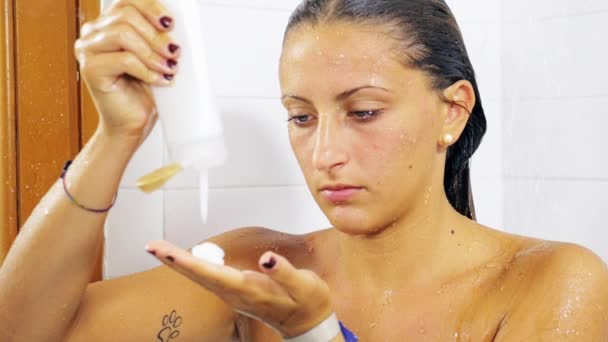 Jeune femme dans la douche mettre conditionneur sur la main au ralenti
 - Séquence, vidéo