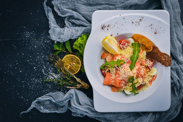 Salad with salted salmon, cheese and salad leaves. On a wooden surface. Top view. Free space for your text. - Foto, imagen
