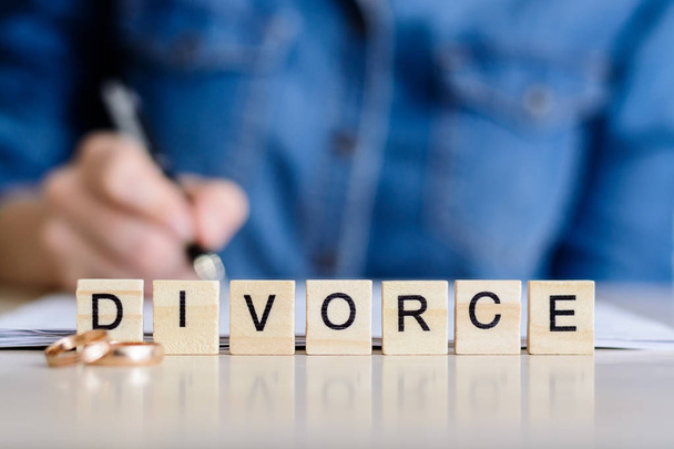 Концепция развода. Развод. Молодая девушка подписывает договор о разводе
 - Фото, изображение