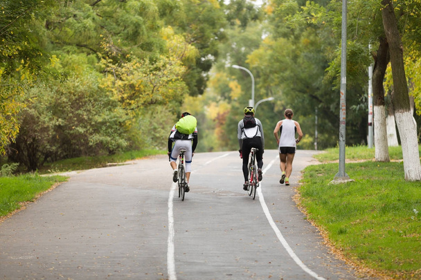 két biciklisták, hátizsákok, séta a parkban - Fotó, kép