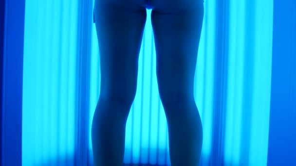 The girl dances in a vertical solarium. Young woman having fun and sunbathing. - Footage, Video