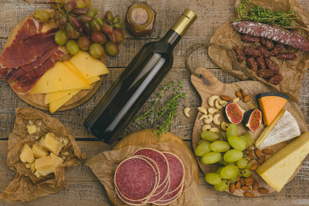 Druiven, witte wijn, kaas, honing en noten over rustieke, verweerde - Foto, afbeelding