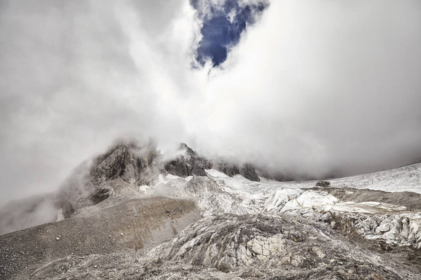 Jade Dragon Snow Mountain pico cubierto de nubes, China
 - Foto, Imagen