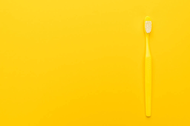 plastic toothbrush on yellow background - Foto, imagen