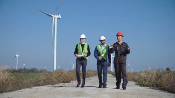 Drei Ingenieure laufen gegen Windpark - Filmmaterial, Video