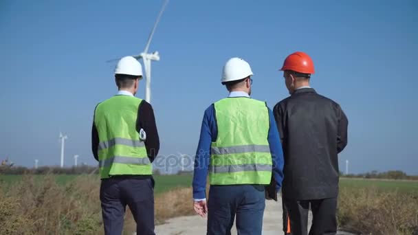 Trzech inżynierów, chodzenie przed farmy wiatrowej - Materiał filmowy, wideo