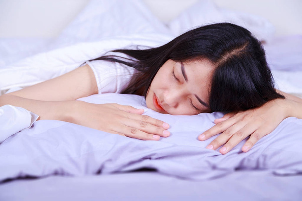 woman sleeping on bed in bedroom - Φωτογραφία, εικόνα