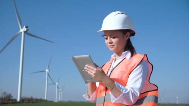 Woman with hard hat against wind turbine - Footage, Video