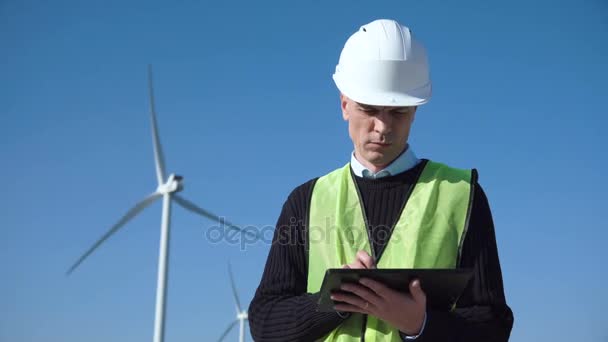 Ingeniero que usa tableta digital contra turbina eólica
 - Imágenes, Vídeo