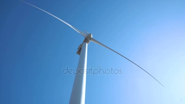 Větrná turbína proti jasné obloze na slunečný den - Záběry, video