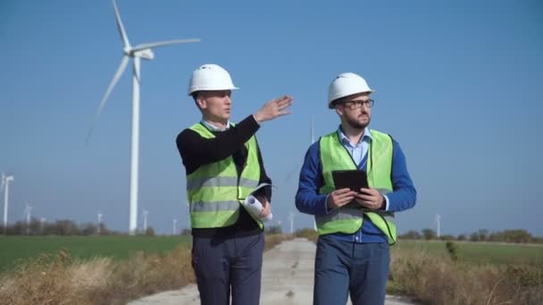 Dwóch inżynierów, omawiając przeciwko farmy wiatrowej - Materiał filmowy, wideo