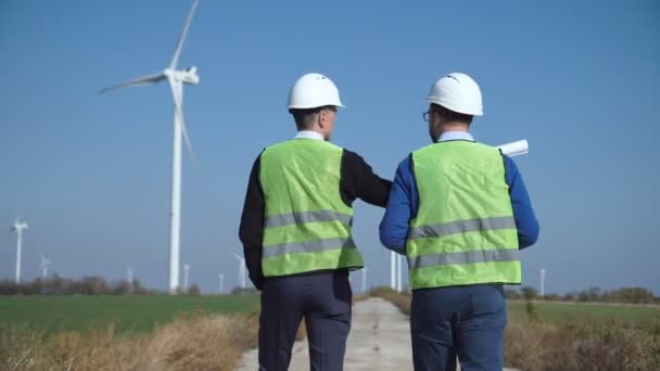 Two engineers discussing against wind farm - Footage, Video
