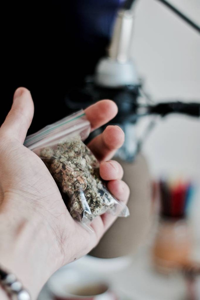 Bolsa con una marihuana en la mano
 - Foto, Imagen