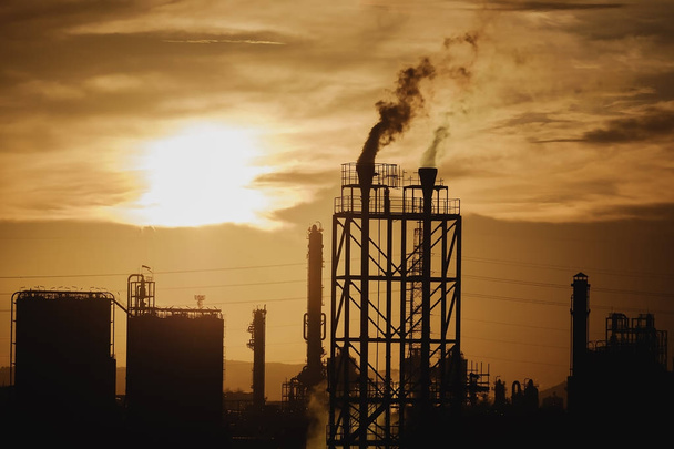 Нефтехимический завод в силуэте изображения на закате неба
 - Фото, изображение