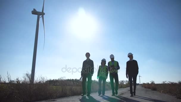 Grupo de engenheiros que caminham ao longo da estrada no parque eólico
 - Filmagem, Vídeo