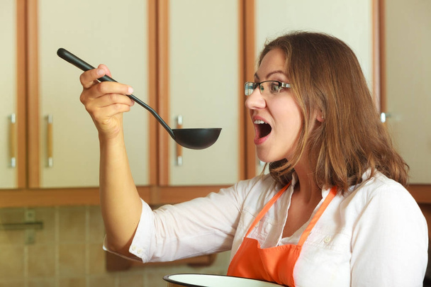 Woman with ladle and pot in kitchen - Valokuva, kuva
