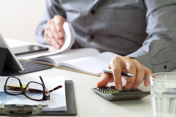 hombre de negocios mano trabajando con las finanzas sobre el costo y la calculadora
 - Foto, imagen