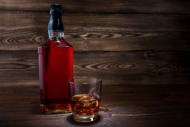 Bottle of whiskey on a wooden background - Fotó, kép