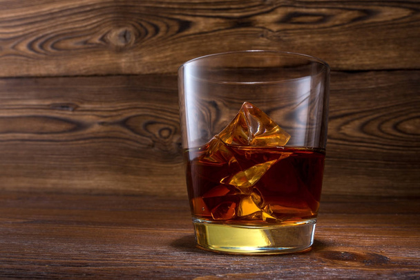 Scotch em fundo de madeira com copyspace. Uma bancada antiga e vintage com destaque e um copo de licor duro - Foto, Imagem