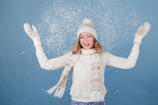Happy girl laughing and playing with snow. Woolen knitted clothes - Photo, Image