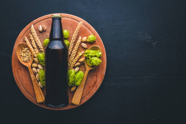 A bottle of beer, hops and grain. Top view. Free space for text. - Zdjęcie, obraz
