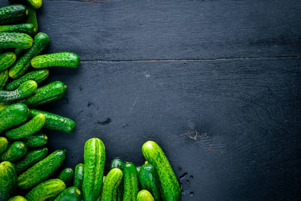 Green cucumbers. On a wooden background. Top view. Free space for text. - Fotografie, Obrázek