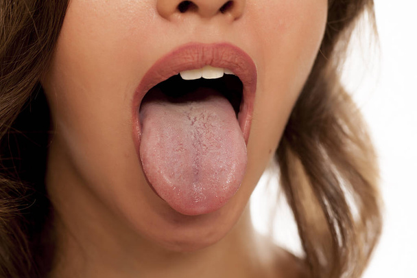彼女の舌を示す若い女性 - 写真・画像