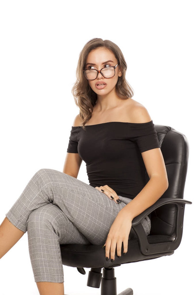 Joven estudiante confundido con anteojos sentado en una silla de oficina
 - Foto, Imagen