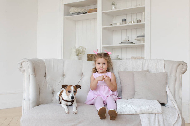 Adorable child with dog on sofa - Foto, imagen
