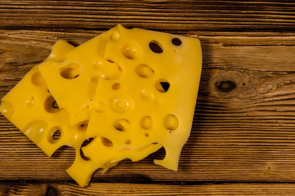 Plakjes van Zwitserse kaas op houten tafel - Foto, afbeelding