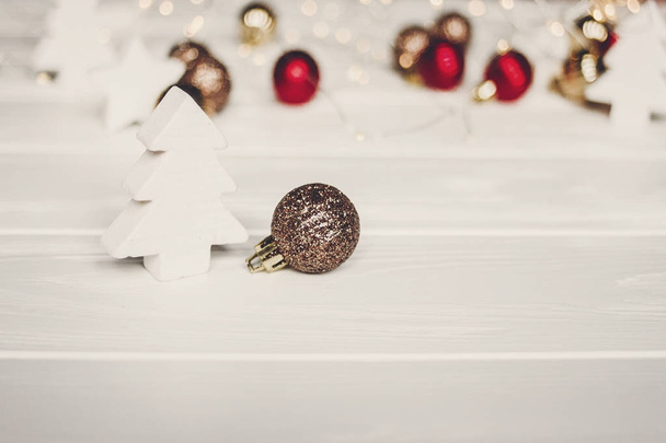 eenvoudige ornamenten en kerstbomen op wit hout met verlichting  - Foto, afbeelding